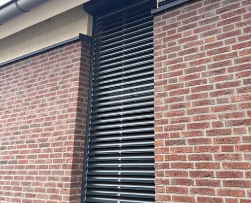 Close-up van een Bubendorff solar jaloezie rolluik in Heumen met zichtbare kantelbare lamellen en solar paneel bovenaan de kast