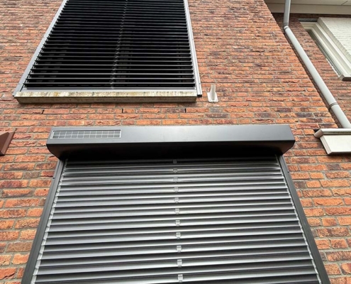 Strakke mat zwarte rolluiken met kantelbare lamellen geplaatst bij moderne woning in Druten.