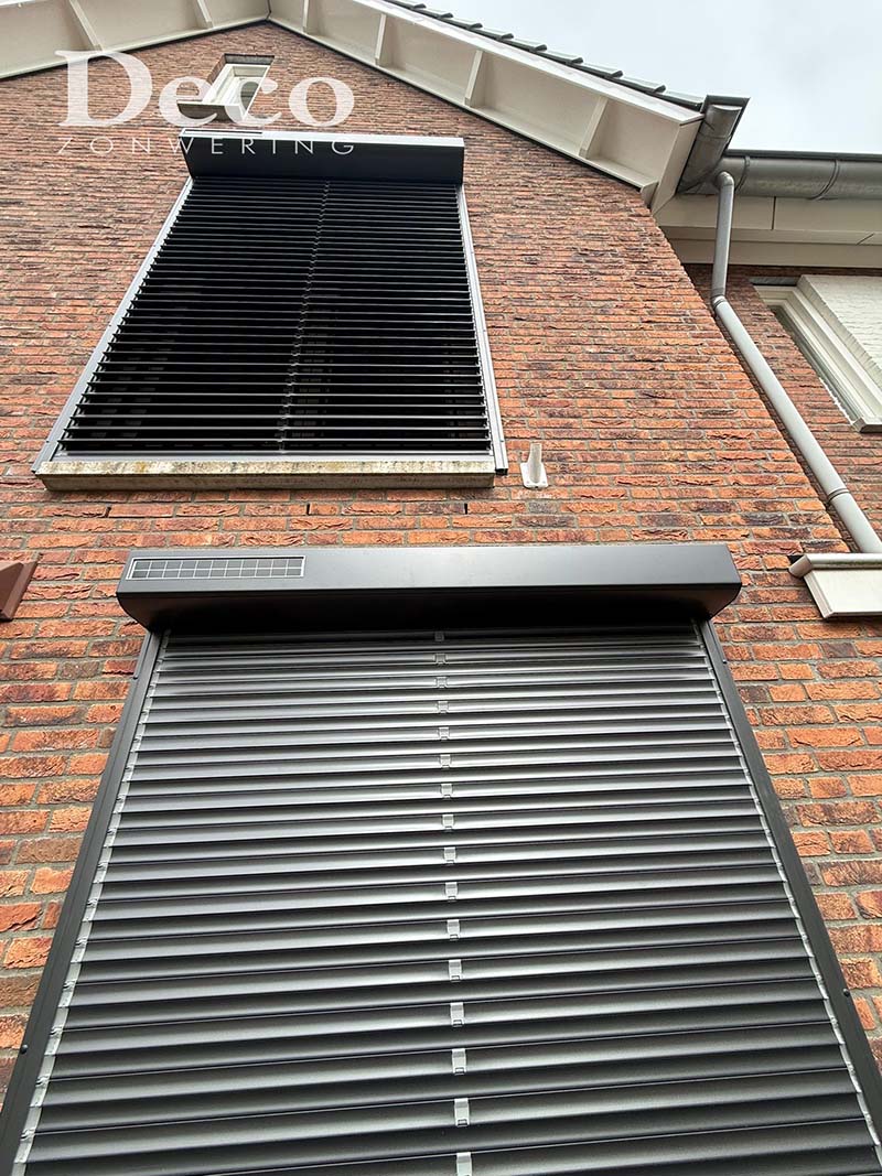 kantelbare-lamellen-mat-zwart Strakke mat zwarte rolluiken met kantelbare lamellen geplaatst bij moderne woning in Druten.