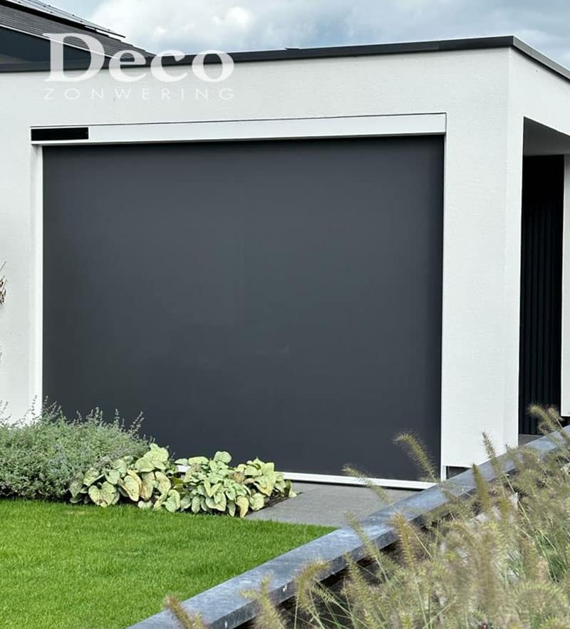 screen-voor-grote-pui-somfy-deco-zonwering Windvaste solar screens in Oss geplaatst bij moderne woning met witte gevel en grote glazen pui.