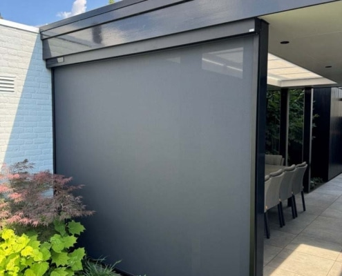 Heroal solar screen buitenaanzicht overkapping Heesch Windvaste Heroal solar screen in antraciet, gezien vanuit de tuin onder de rand van de overkapping in Heesch