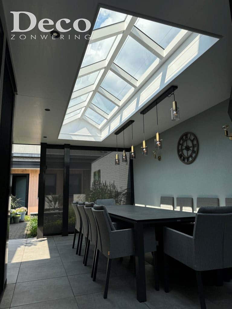 Grote piramidevormige lichtstraat in een vaste overkapping in Heesch, gezien vanuit de eetkamer met zicht op de lucht