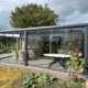 Tuinkamer met glazen zijwand en gesloten aluminium privacywand in Oisterwijk