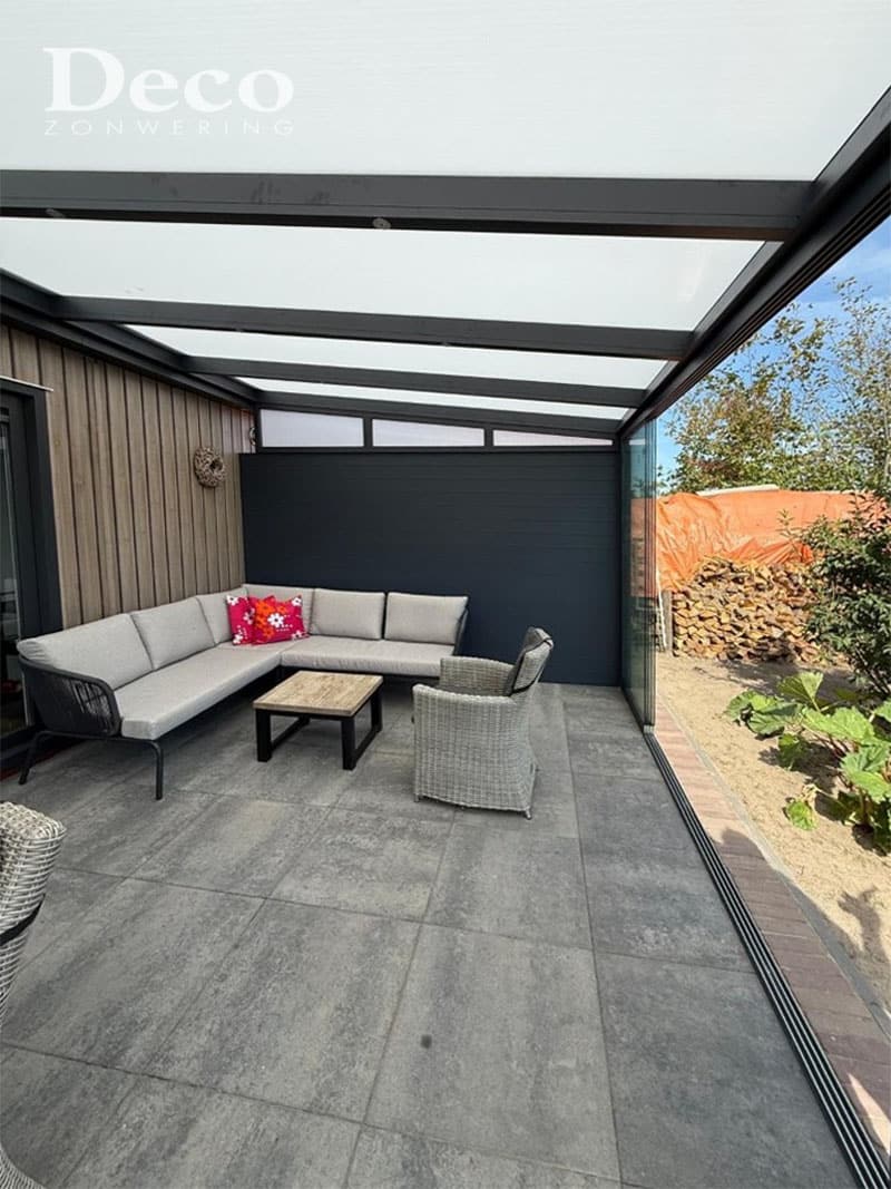 Binnenzijde van tuinkamer met opaal polycarbonaat dak en glazen schuifwand in Oisterwijk