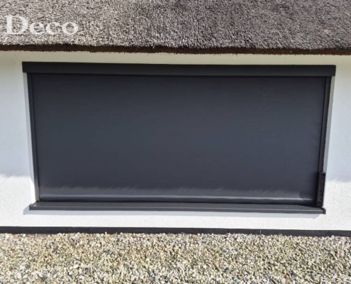 los-solarpaneel-screen-rieten-dak Donker solar screen in RAL 7021 structuurlak onder de rieten dakrand van een woning in Heesch.